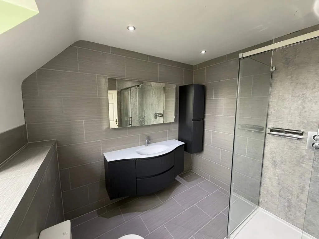 Grey-tiled bathroom installation in Nantwich with shower and vanity | view 2
