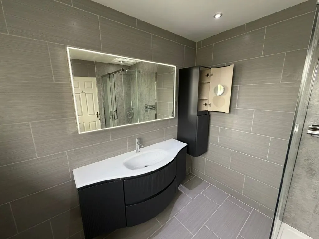 Grey-tiled bathroom installation in Nantwich with shower and vanity | view 3
