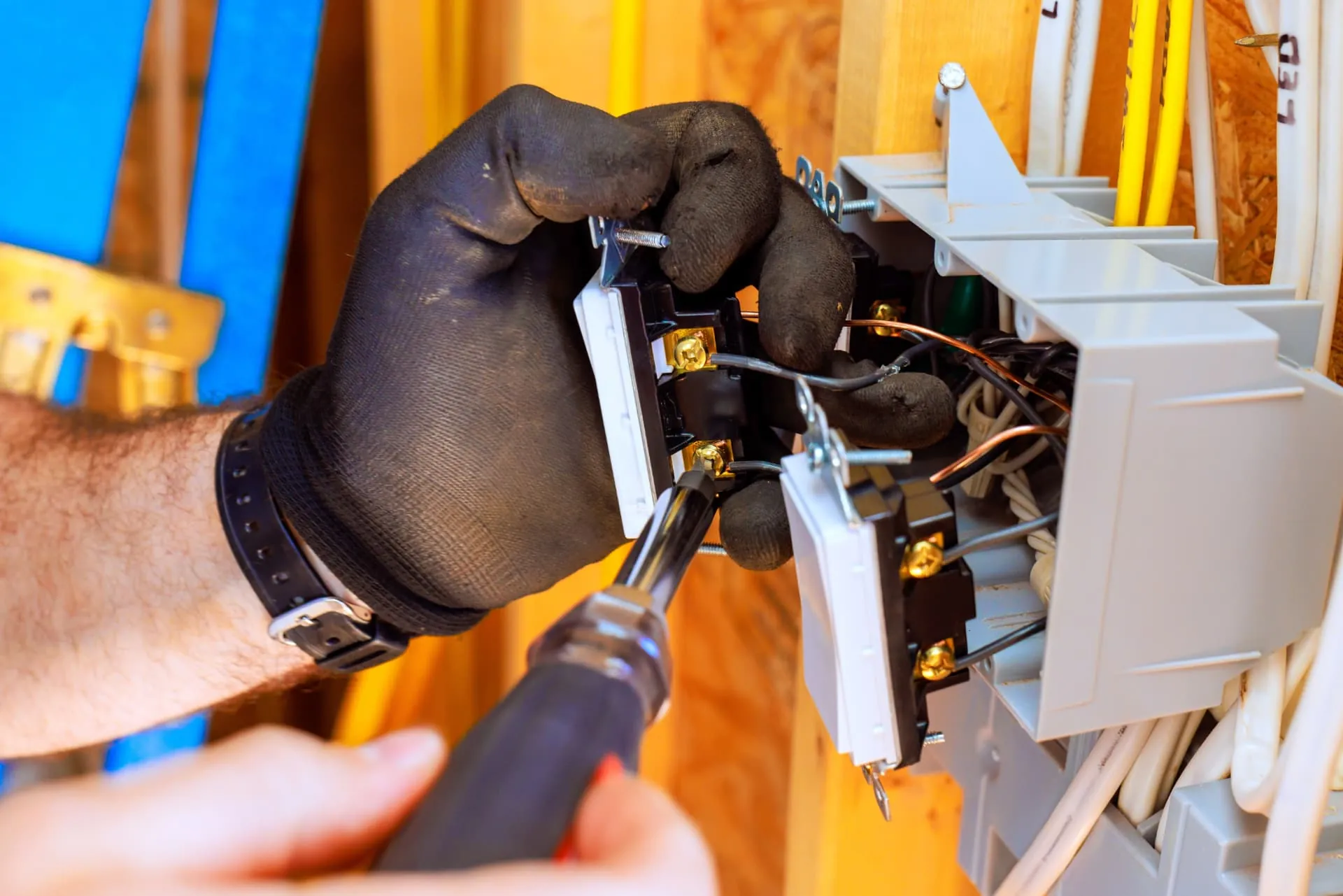 Electrician wiring a switch into a back box