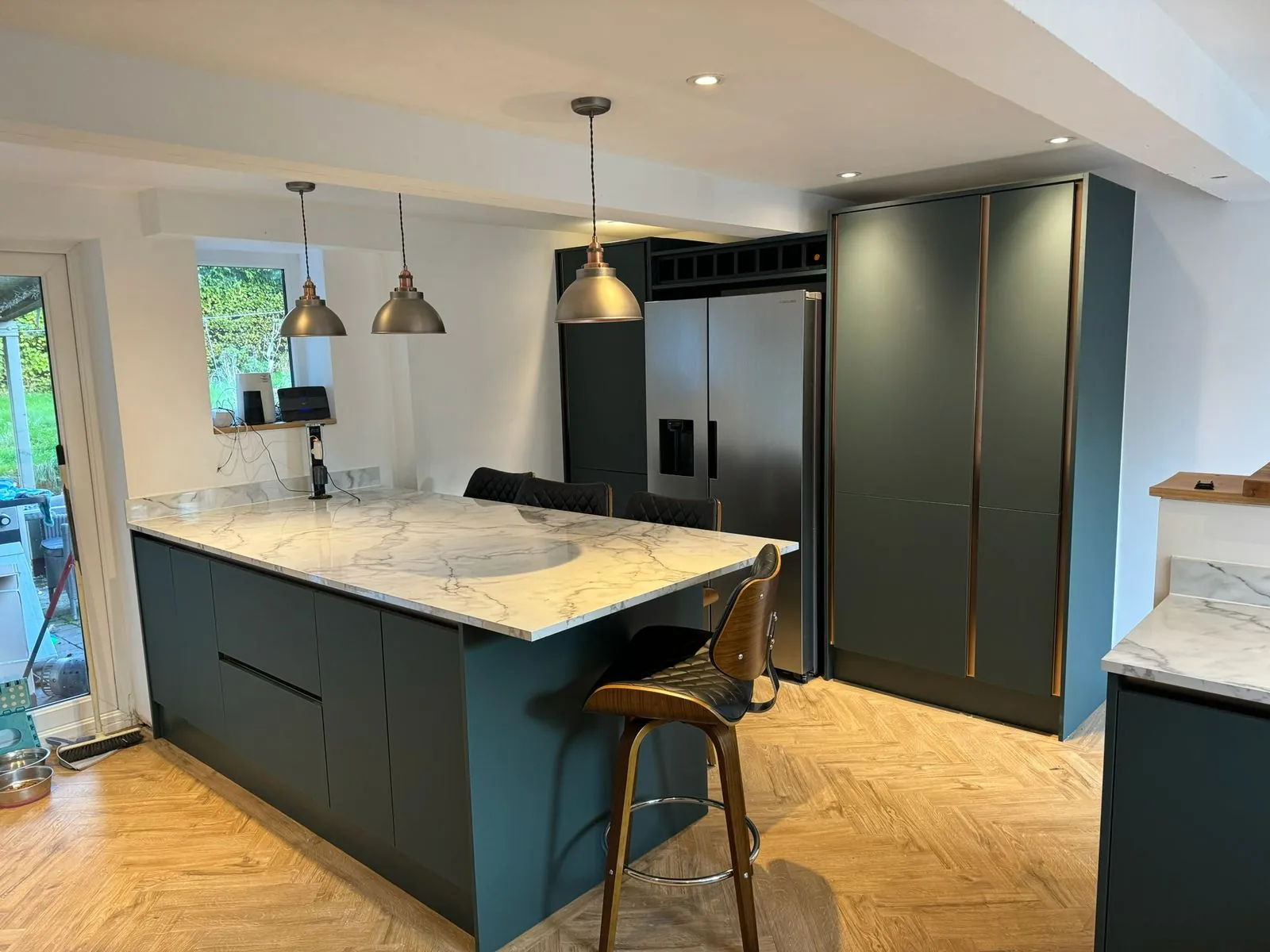 Full kitchen fit-out with dark green units, marble-effect island and herringbone floor | view 5