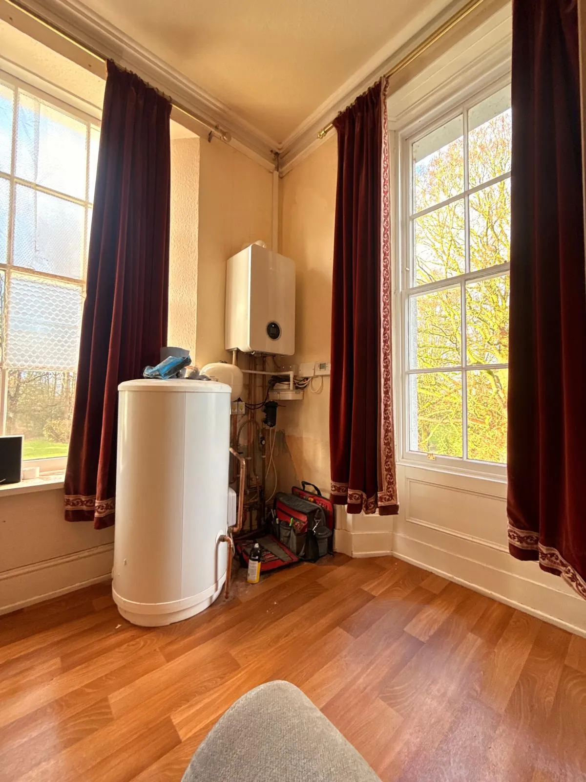 Wall-mounted boiler and hot-water cylinder ready for servicing