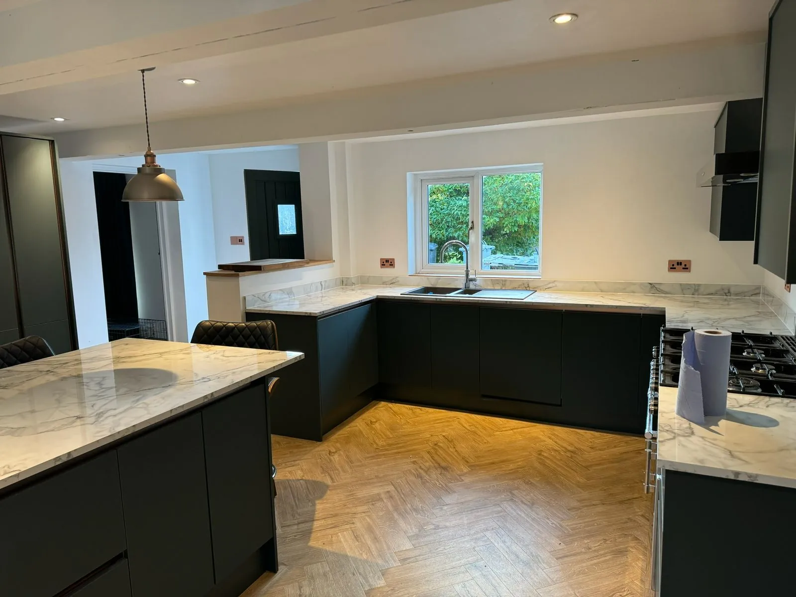 Full kitchen fit-out with dark green units, marble-effect island and herringbone floor | view 4