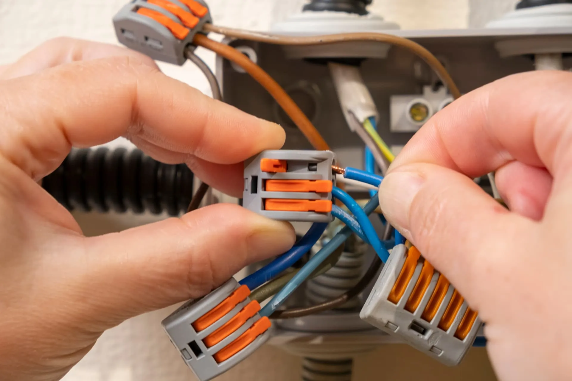Electrician connecting wires in a junction box during a rewire