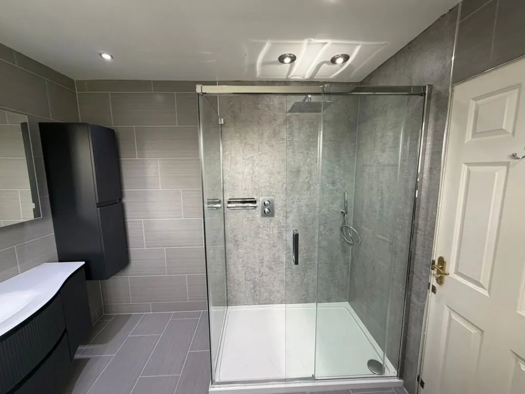 Grey-tiled bathroom installation in Nantwich with shower and vanity by Warm-Wise